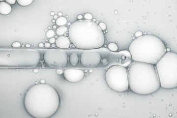 Liquid beauty product gray gel or serum on white glass of microscope background