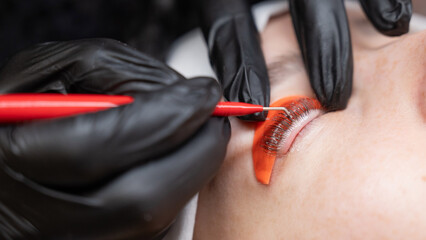 Caucasian woman undergoing eyelash lamination procedure. 