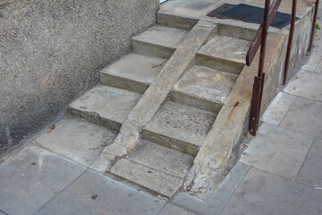 Wooden construction ladder placed on concrete steps near residential building showing construction...