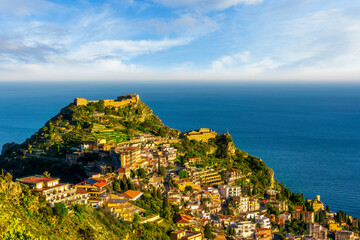 scenic view at beautiful mountain town on a sea coast in Italy with green hills, antique buildings...