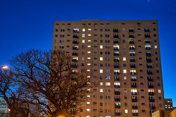 lights in windows of modern residential building in the evening in the city of Poznan