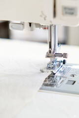 sewing machine with a cloth under a steel needle. manufacture of clothing. a household or industrial sewing machine. tailor, couturier. work on sewing designer clothes.