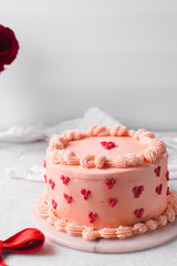 Pink buttercream cake on a cake plate, Cake covered in buttercream hearts, process of decorating a cake with red buttercream hearts