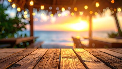 Wooden table at beachside restaurant at sunset. Blurred background of beach, ocean and lights
