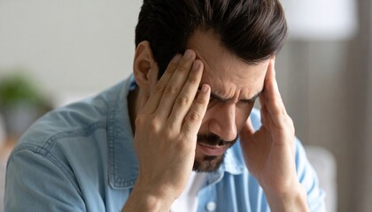 Stress and frustration shown by a man holding his head in distress representing emotional or financial pressure