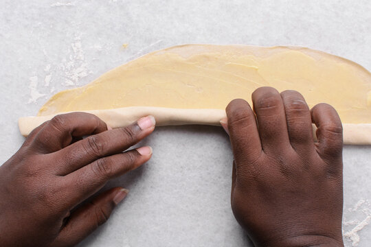 Overhead view of rolled paratha dough on a marble countertop, top view of flaky flatbread dough, process of making paratha