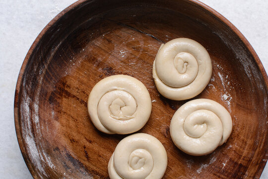 Overhead view of rolled paratha dough, top view of flaky flatbread dough, process of making paratha