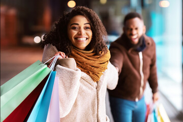 It's Shopping Time. Portrait Of Cheerful Excited African American Woman Pulling Her Man To Mall...