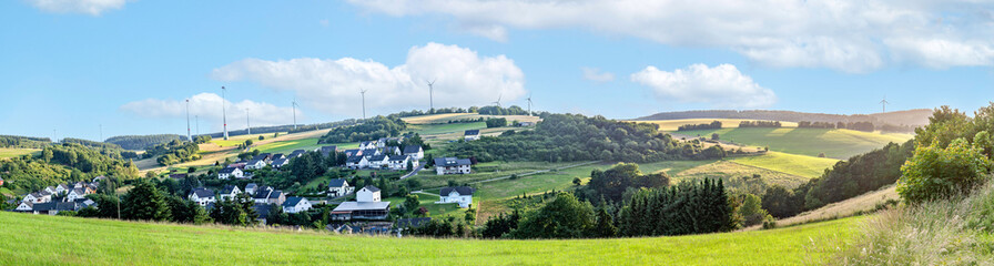 scenic Eifel landscape with hilly landscape and wind generator in background