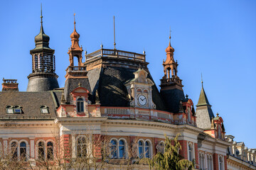 Fototapeta premium Historic european architectural building with red spires and clock on a sunny day