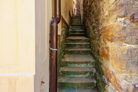 Narrow stone alleyway with steep stairs between old buildings