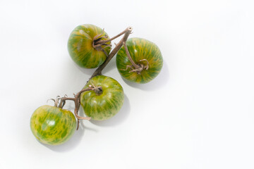 Green striped tomatoes with yellow stripes on a white background. Photo for a banner.