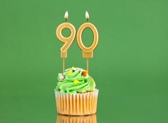 Number 90 birthday candle - Cupcake on a green background
