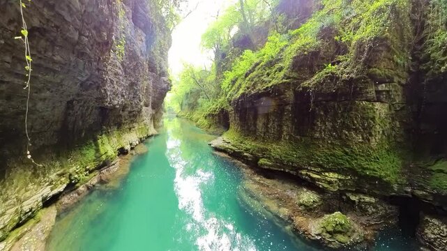 Crystal clear water flowing through Martvili Canyon in Georgia, with waterfalls cascading down mossy rocks into the Abasha River, creating a picturesque natural landscape