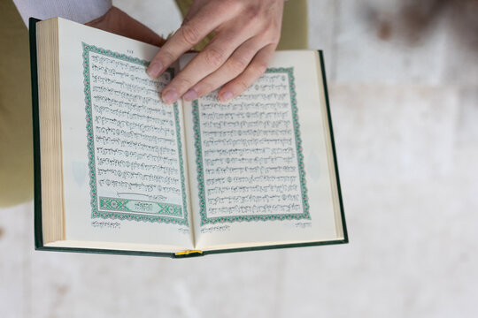 man scrolling through Quran