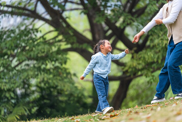 happy  little girl playing in the spring park with her mother 