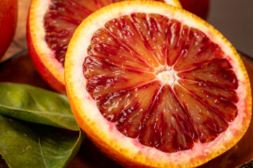 Sicilian sweet juicy yellow and red blood oranges with green leaves close-up