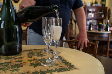 Pouring and tasting of dry sparkling wine brut, grand reserve, champagne in Ay-Champagne wine making village in Vallee de la Marne, , Champagne region, France
