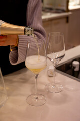 Tasting of brut champagne sparkling wine produced by traditional method in underground caves close up, pouring of wine