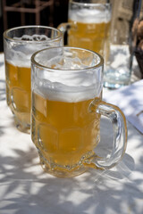 Belgian beer in glasses in old brewery in Bruges, light or dark, tasty beverage, lunch with beer, tourist destination, Flanders, Belgium