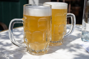 Belgian beer in glasses in old brewery in Bruges, light or dark, tasty beverage, lunch with beer, tourist destination, Flanders, Belgium