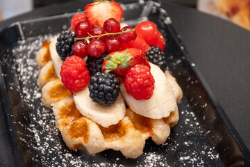 Baked belgian sugar waffles with various toppings, delicious sweet street food in Bruges, Flanders,...