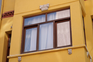 Decorative windows on a bright yellow building exterior