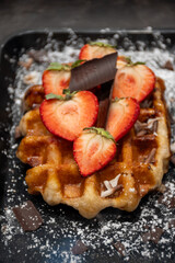 Baked belgian sugar waffles with various toppings, delicious sweet street food in Bruges, Flanders, Belgium