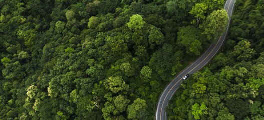 Electric cars to protect the environment and transportation road of Top view road in beautiful Rain forest with natural background, landscape view from flying drone in Nature