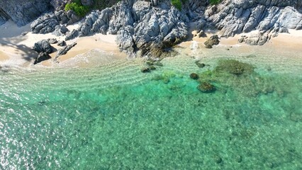 This aerial shot of a tranquil beach highlights eco-friendly resorts and accommodations, promoting sustainable stays for nature-conscious travelers. Phuket, Thailand.
