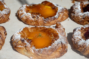 Fresh baked buttered fruit and sweet buns, cakes, pastries in artisan bakery early morning in Bruges, Belgium