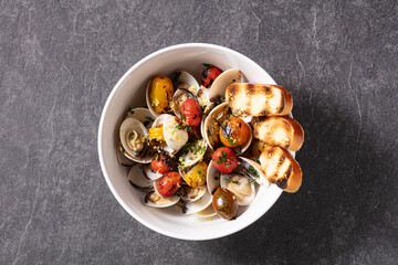 White bowl of frshly cooked clams and roasted tomatoes