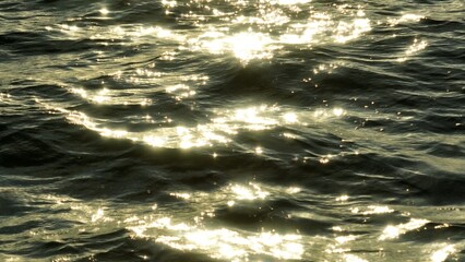 An aerial view of the ocean’s golden reflections brings a sense of serenity, where the gentle ripples of the water combine with the glowing light to create a peaceful, breathtaking landscape.