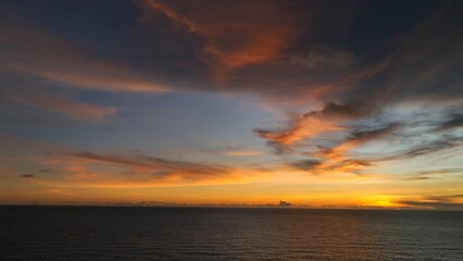 The tropical sea from above, bathed in the soft glow of sunset, as the tranquil water reflects the stunning colors of the sky, creating a serene and picturesque scene. Thailand.
