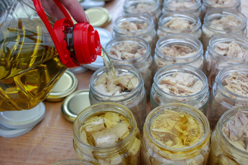 adding olive oil to the tuna for preservation