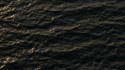 Obraz premium The ocean’s waves are illuminated by the warm glow of the sun, with golden sparkles reflecting on the water’s surface, creating an enchanting and peaceful atmosphere. 