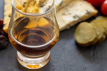 Whiskey and cheese pairing, tasting whisky glass and plate with sliced blue stilton and blue shropshire cheeses, Great Britain food and drink