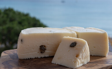 Primo Sale hard cheese made from whole mixed milk, with thin white rind and texture of Sicilian basket fascedde with pickled capers and sea view on Mondello beach nea Palermo, Sicily