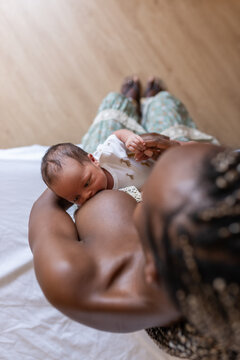 Woman breastfeeding hungry newborn on bed