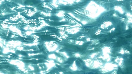 Captured from the sky, the tropical ocean’s shimmering surface glows under the sunlight. The clear blue water, with its gentle ripples, creates a soothing natural scene of beauty and serenity.
