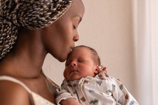 Woman kissing her baby forehead