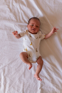 Newborn baby lying on parents bed