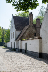 Medieval convent for nuns who weave lace in Bruges, Flanders, small white houses and a park inside the monastery walls, Belgium
