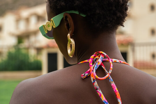 Woman wearing sunglasses and golden earrings outdoors