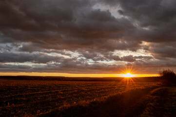 Natural beautiful clouds at dawn. Dramatic colorful red-orange to dark gray sky with clouds at...
