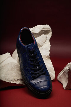 Stylish blue sneaker on rocky display background