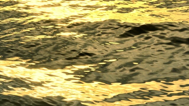 The golden reflections of sunlight dancing on calm ocean waters, creating a shimmering, ethereal effect that captures the peaceful and majestic beauty of the sea at sunset.
