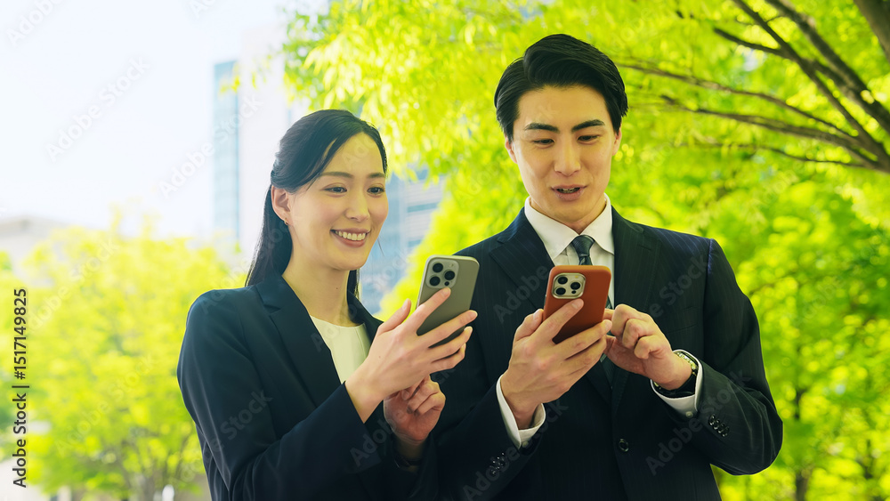 Poster スマホ、スマートフォン、アプリ、見せる、動画、ニュース、ビジネスパーソン、屋外、日本人、ビジネスマン、ビジネスウーマン、仕事、携帯電話、会話、話す、共有、連携、インターネット、オンライン、Web、通信、マッチング、モバイル、SNS、ソーシャルメディア、ユーザー、新緑、都市、営業、メール、検索、クチコミ、口コミ、GPS、レビュー、笑顔、女性、男性、ビジネス、チームワーク、二人、パートナー、情報、メッ