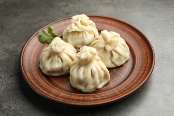 Delicious khinkali served on grey table, closeup