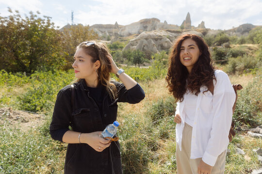 Two young women walk along a stone road in Cappadocia